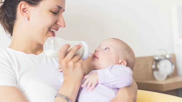 Mother feeding her baby with the feeding bottle