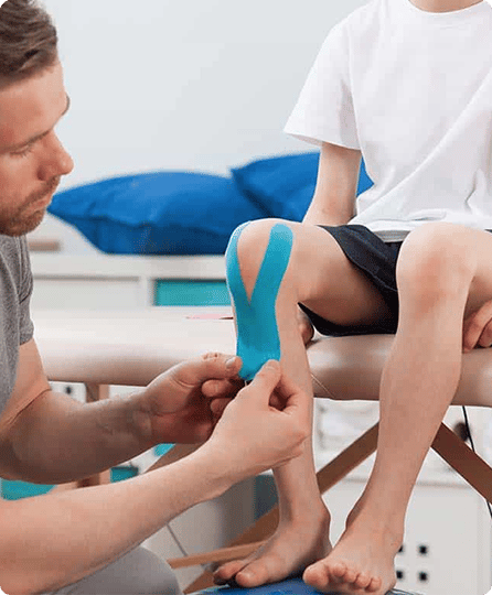Man helping a boy with his knee injury