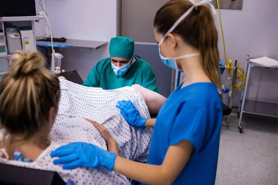 Pregnant woman in labor with two doctors
