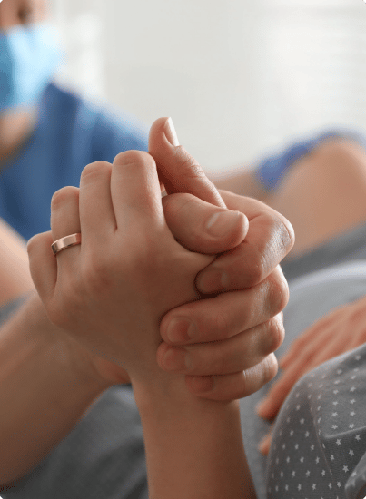 Man holding the palm hand of a pregnant woman in labor
